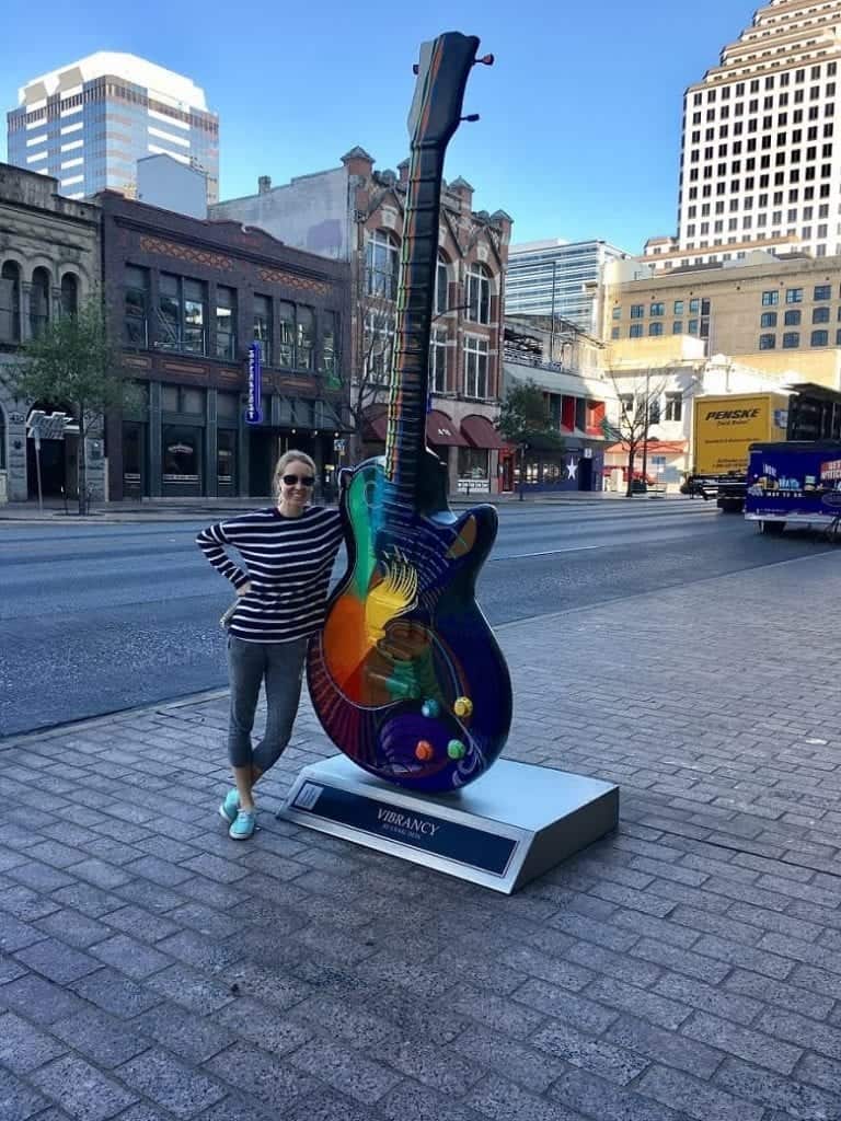 girl standing next to guitar in downtown Austin, Texas
