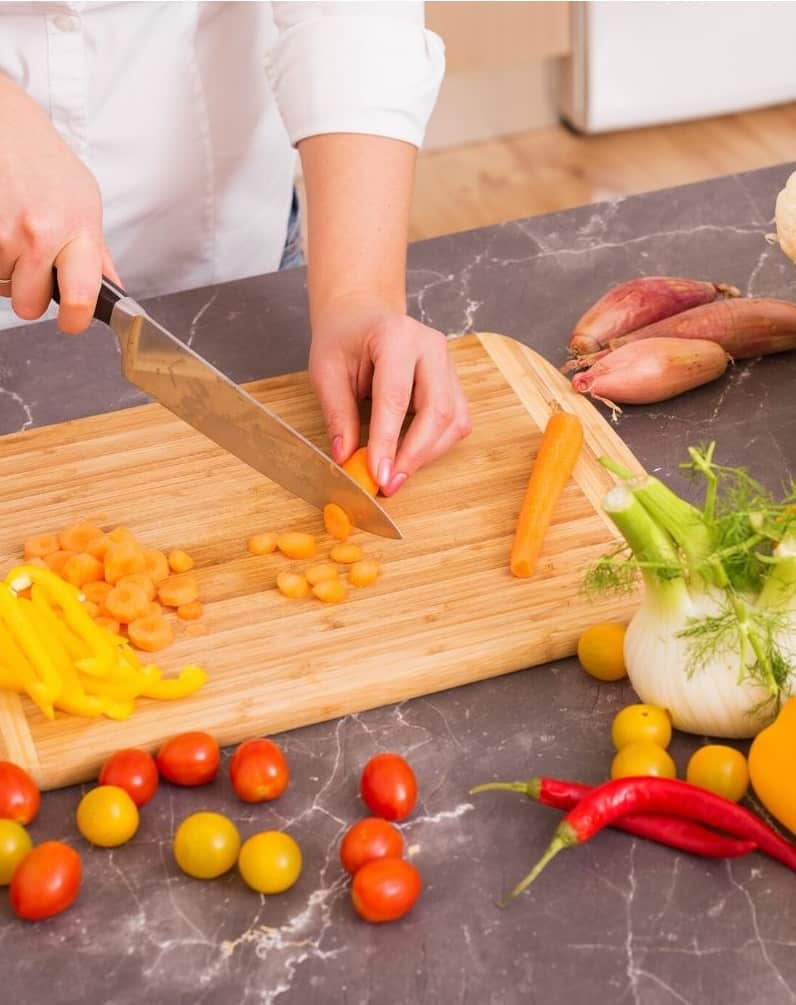 chopping vegetables on cutting board for meal prep | Bucket List Tummy