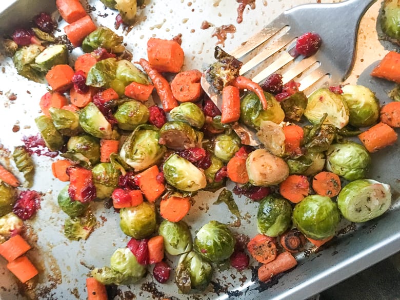 Balsamic glazed brussel sprouts with carrots and cranberries on baking sheet
