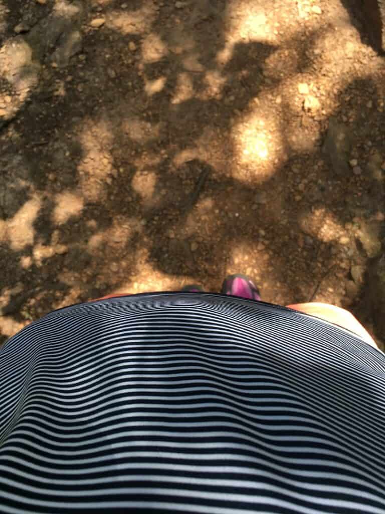Pregnant woman with belly sticking out on walking trail