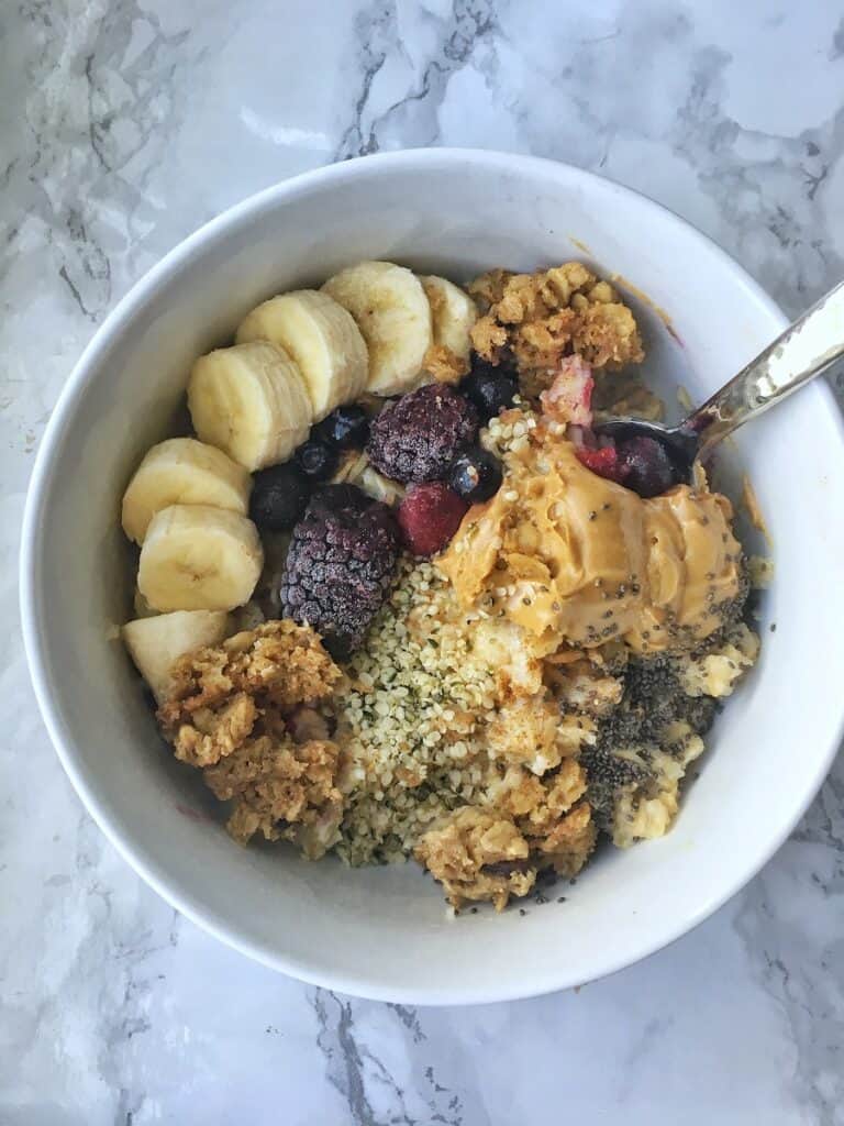 bowl of oatmeal with fruit and peanut butter