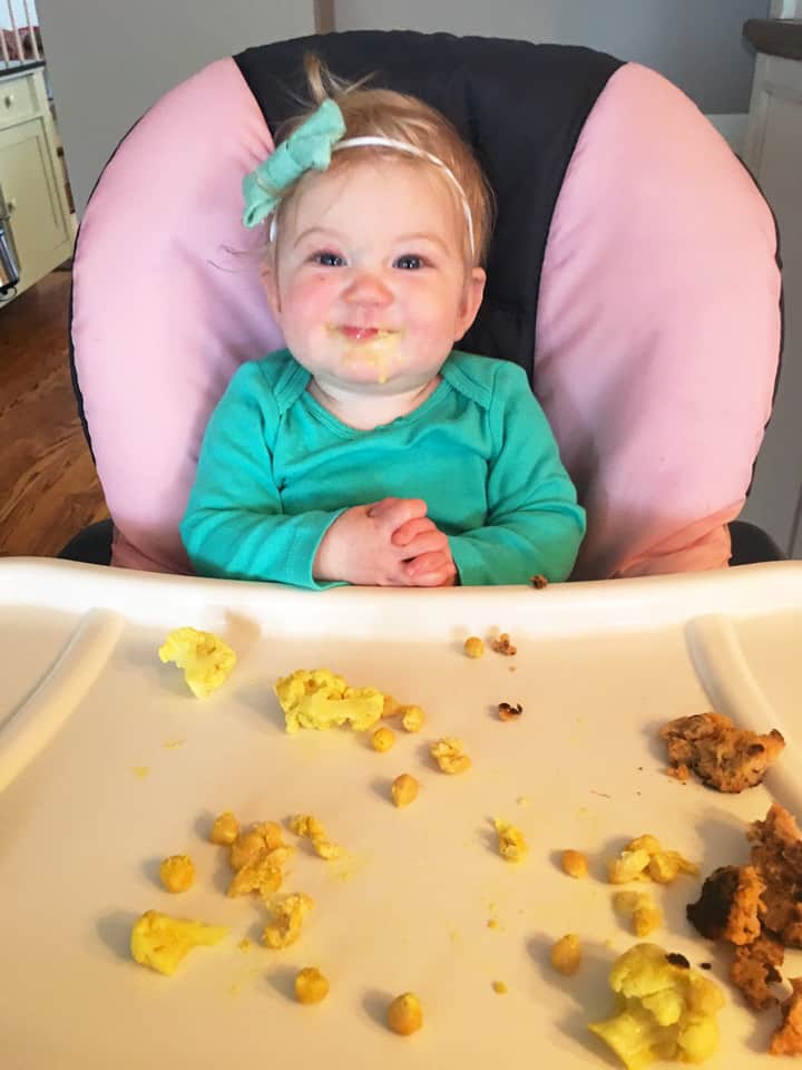 baby eating eggs and solids in high chair