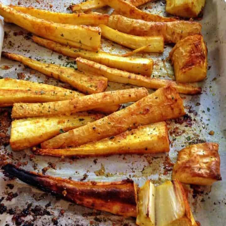 Roasted parsnip fries on a baking dish seasoned with garlic and turmeric | Bucket List Tummy