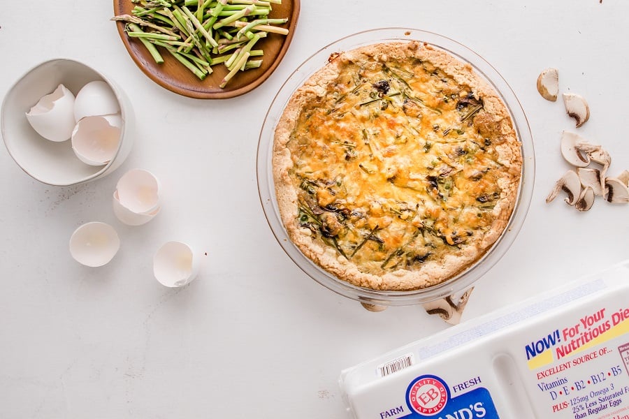 asparagus and mushroom quiche on white countertop