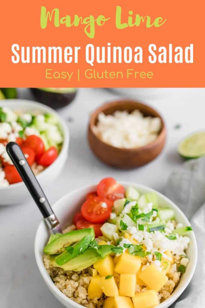 Bowl of summer quinoa salad with sliced mangos, lime and tomatoes with a fork