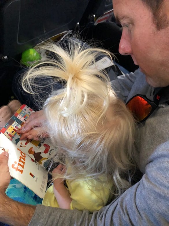 toddler reading book on airplane