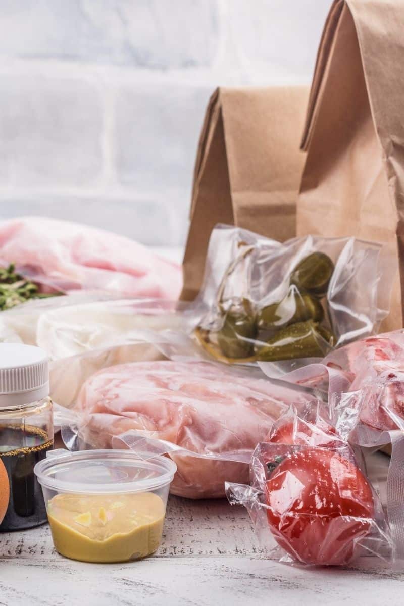 brown paper bag with plastic wrapped food ingredients for meal prep