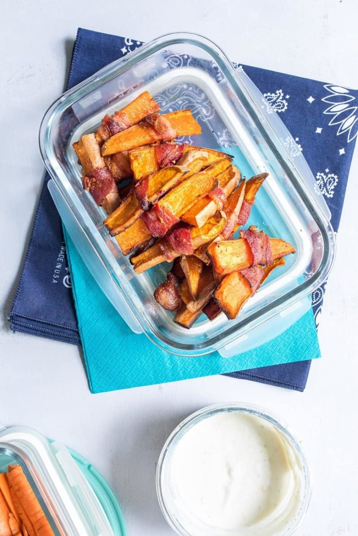 sweet potato wedges in clear tupperware on blue napkin with side of greek yogurt dip