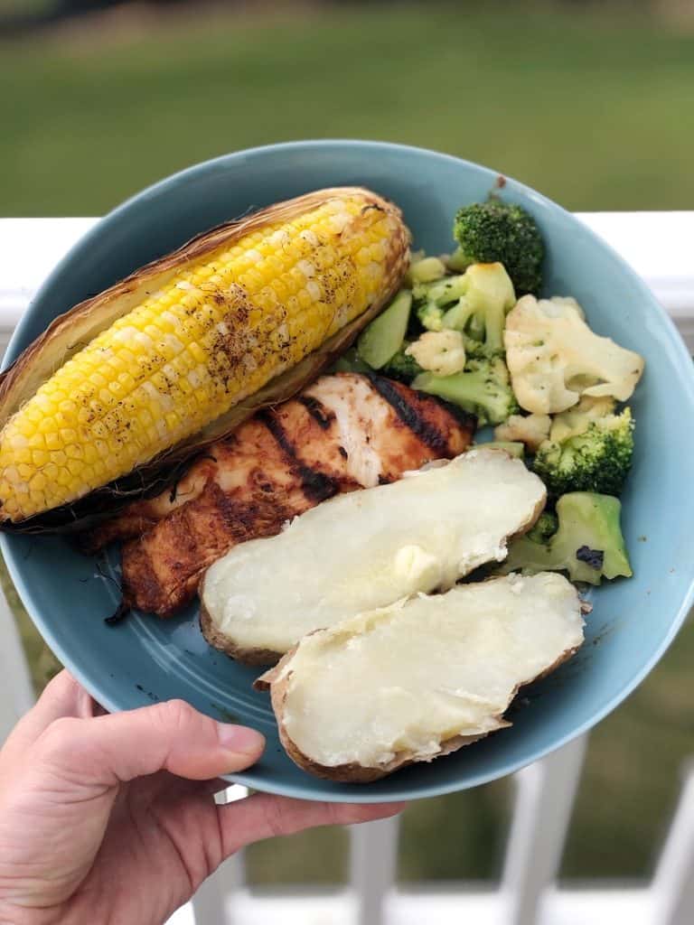 blue plate with corn, baked potato, chicken and broccoli