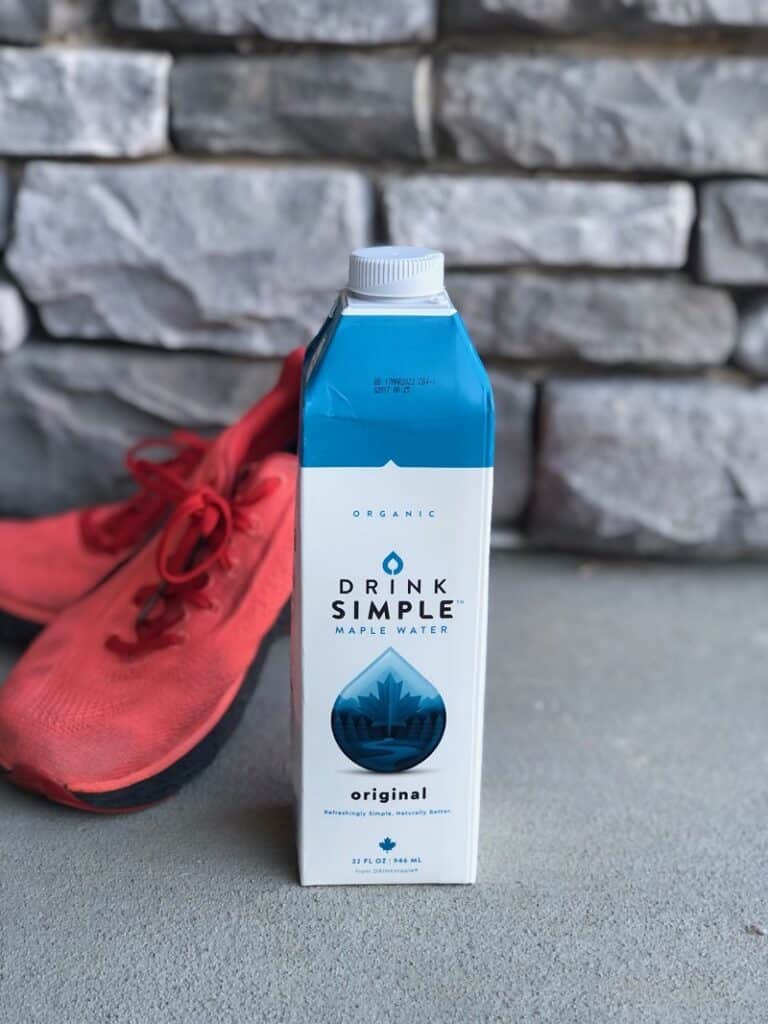 drink simple maple water carton in front of a pair of orange running shoes