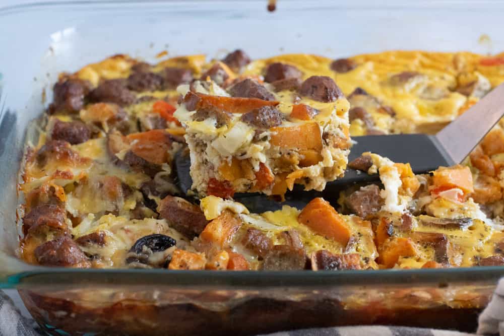 serving spoon with piece of veggie and sausage breakfast casserole on it