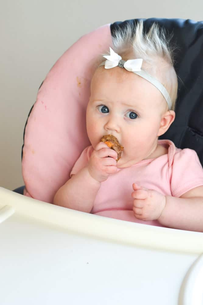 Baby biting into turkey meatballs for baby