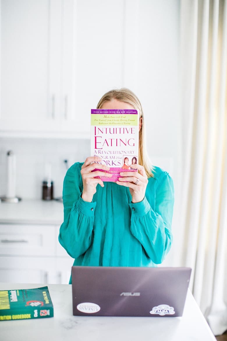 dietitian holding intuitive eating book