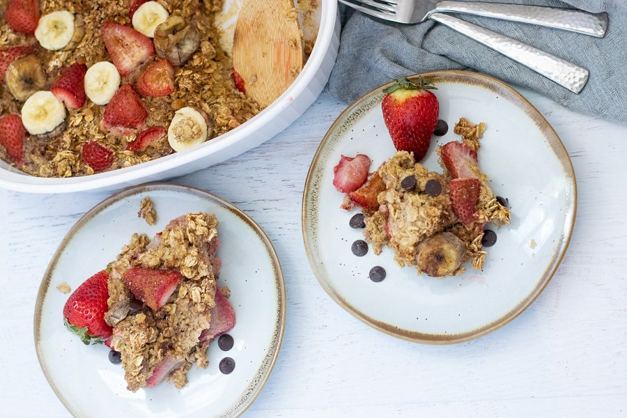 baking dish and two plates with strawberries and baked oatmeal
