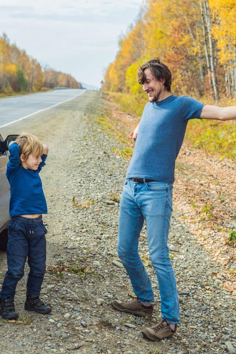 dad and boy stretching on side of road