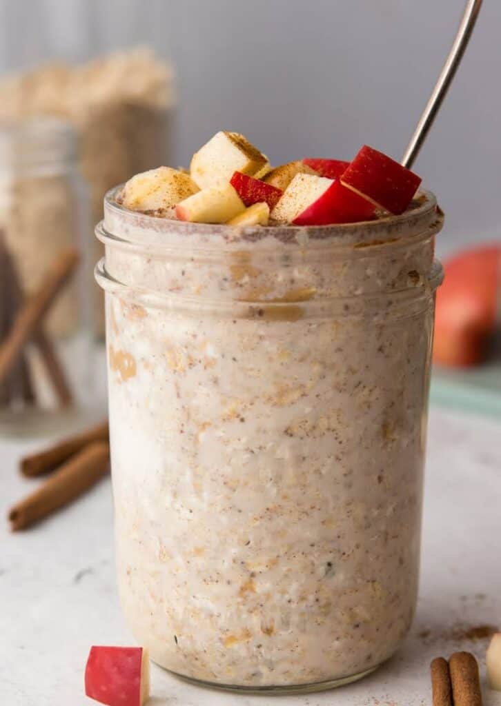 Apple pie overnight oats topped with diced red apples in mason jar