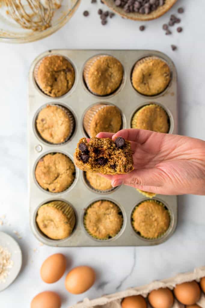 holding zucchini almond flour muffin with chocolate chips