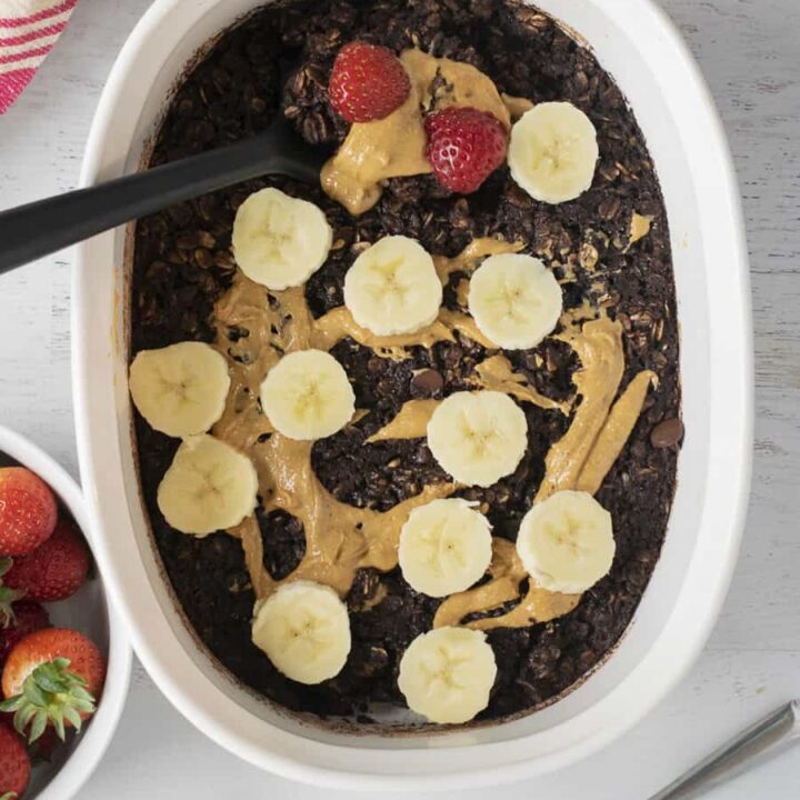 baked oats with chocolate and bananas in white casserole dish after baking