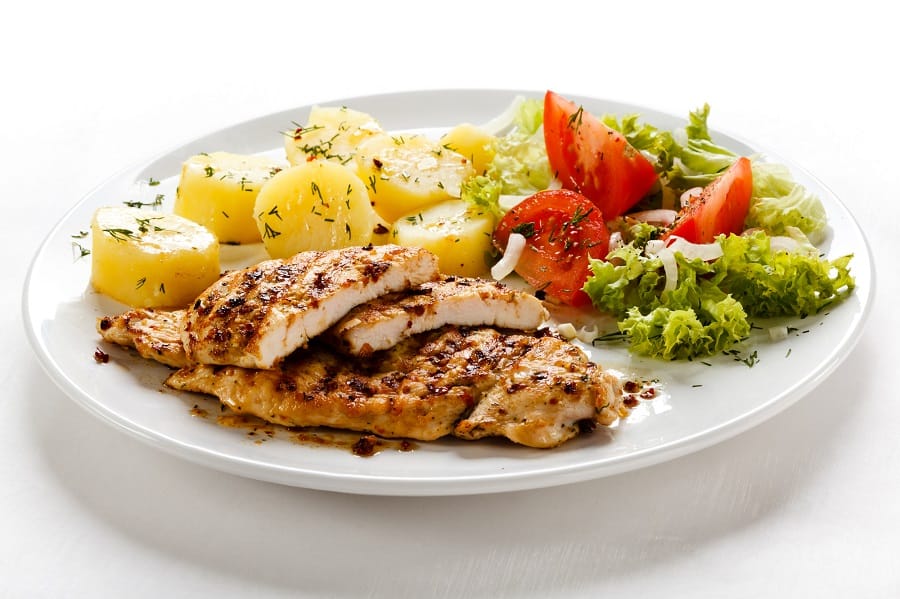 white plate with chicken, potatoes and vegetables