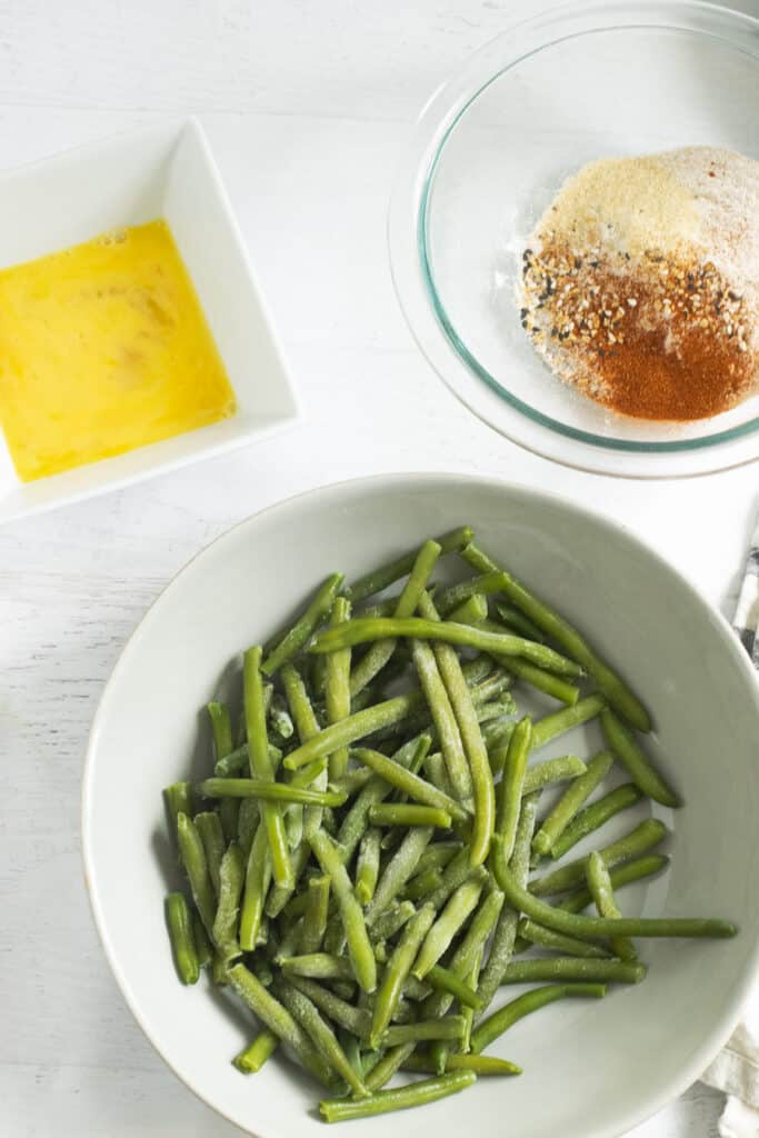 frozen green beans in white bowl with spices