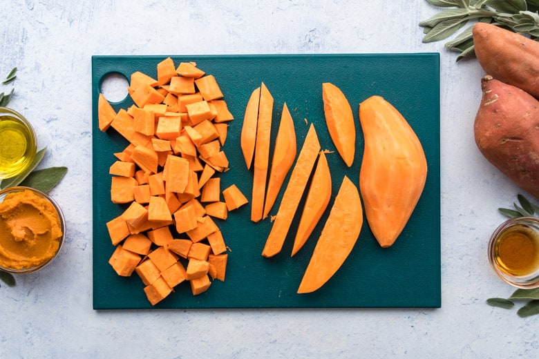 teal cutting board with diced sweet potatoes