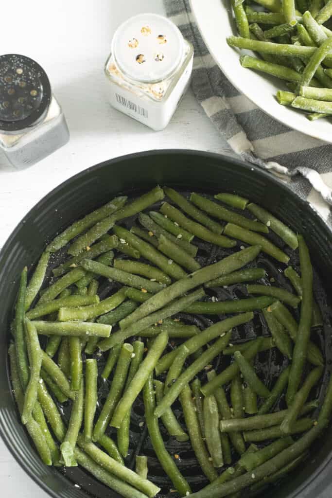 frozen crispy green beans with spices in air fryer tub