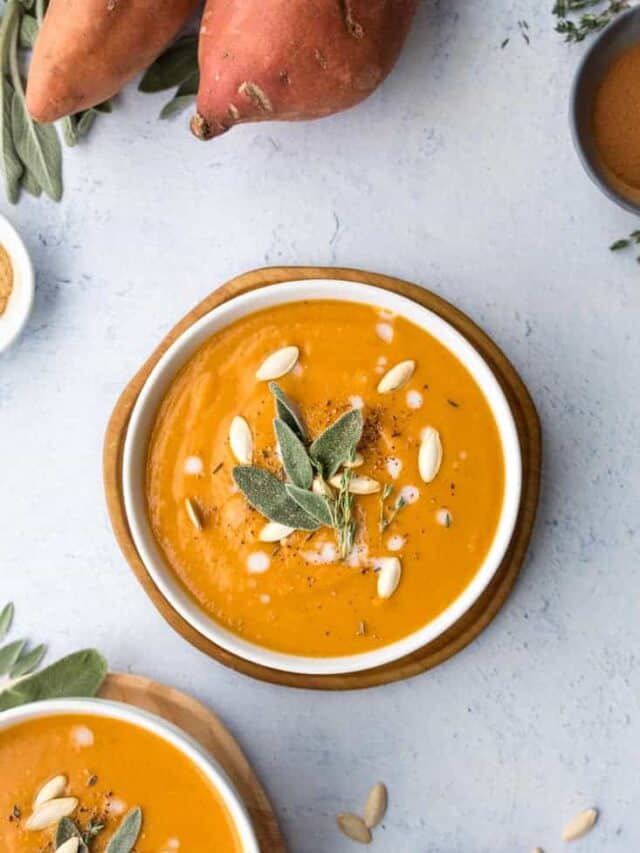 pumpkin sweet potato soup in white bowl topped with pepitas