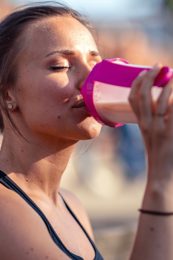 runner drinking pink smoothie after a run