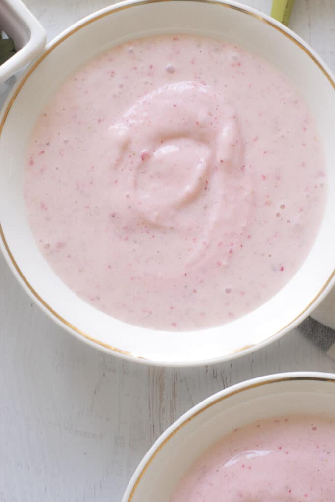 thick strawberry and banana smoothie in a white bowl