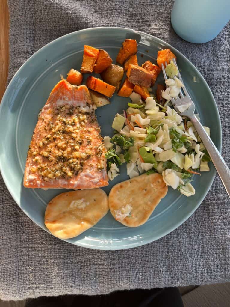Butcher box salmon with sweetpotatoes and salad on blue plate