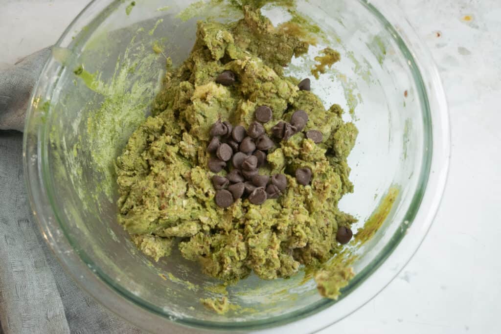 batter for matcha muffins with chocolate chips in clear bowl