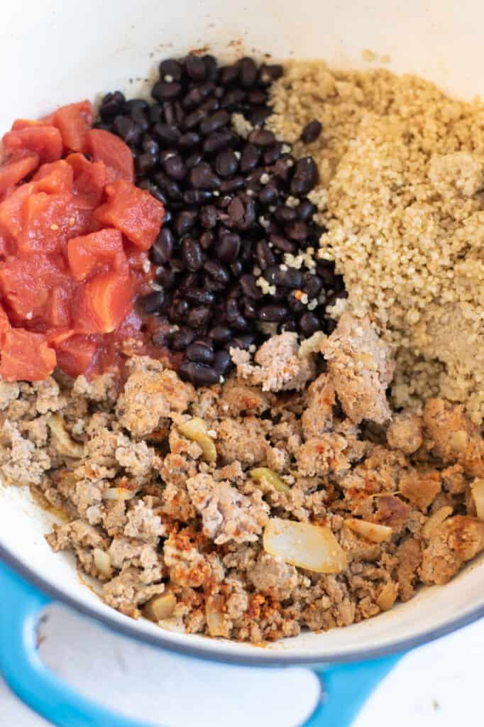 ground turkey, canned tomatoes, black beans and quinoa in blue pot