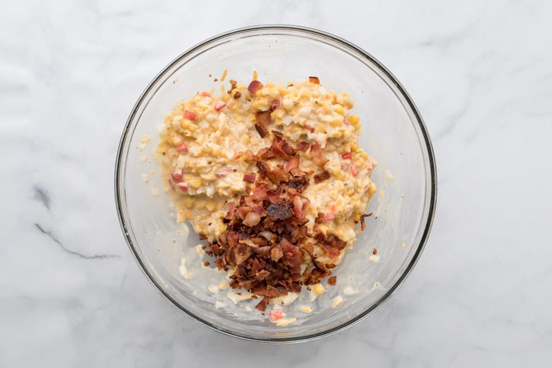 mixing bowl with ingredients for corn fritter with bacon bits