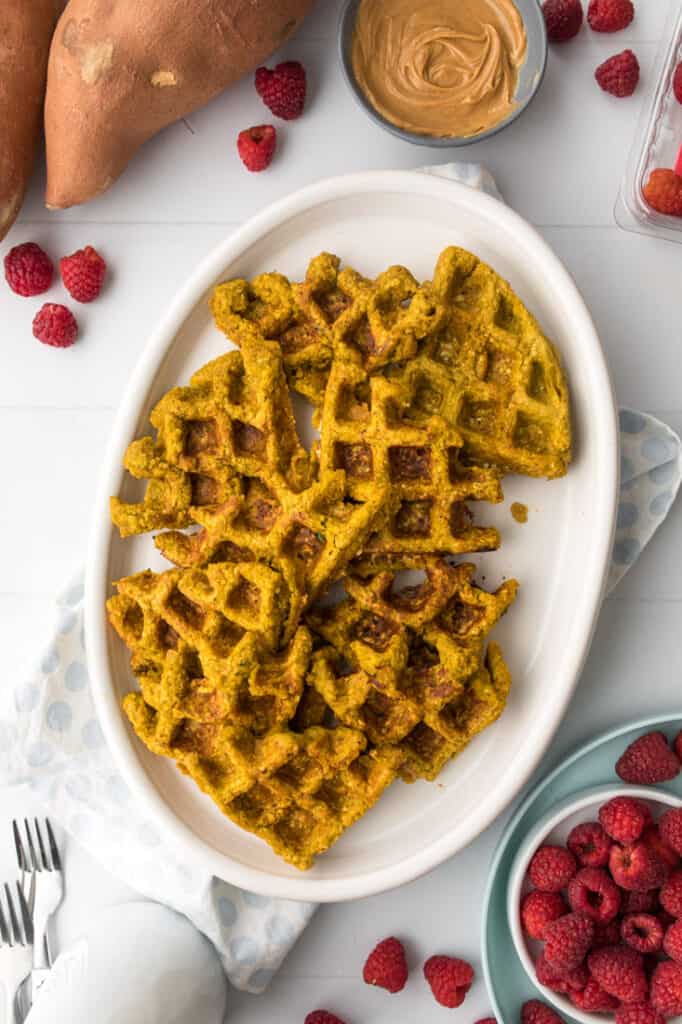 waffles for babies on white plate with raspberries for serving