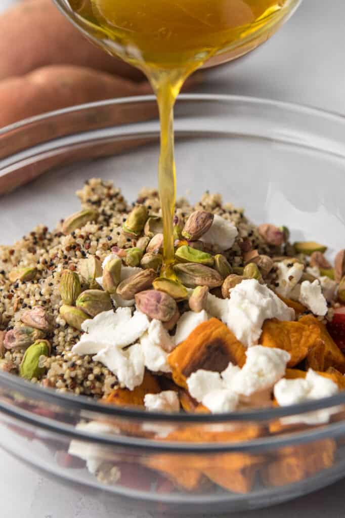 clear bowl with ingredients for sweet potato and quinoa salad with honey citrus dressing