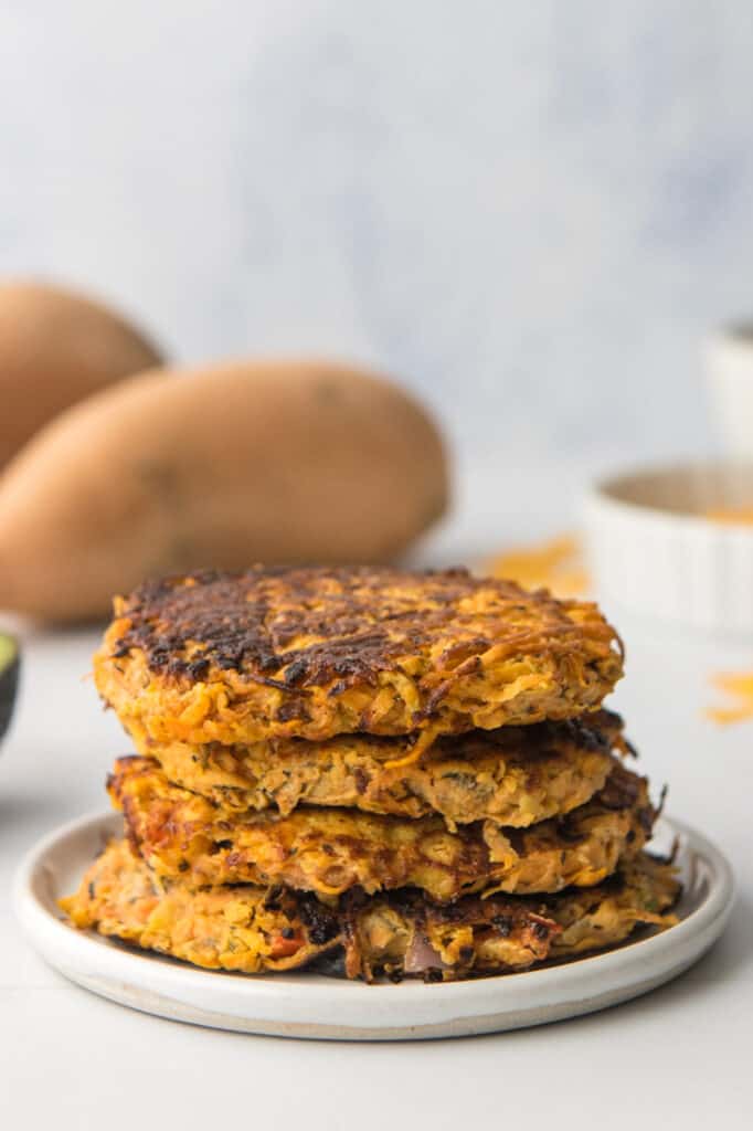stack of zucchini and sweet potato fritters on white plate
