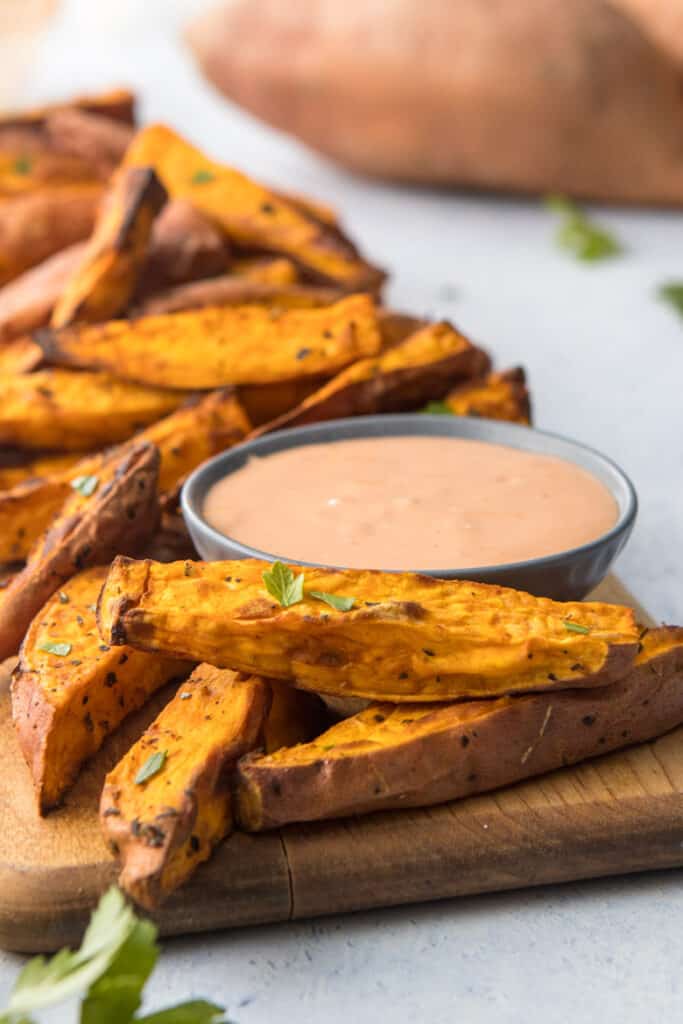 air fried sweet potato wedges on cutting board with dip