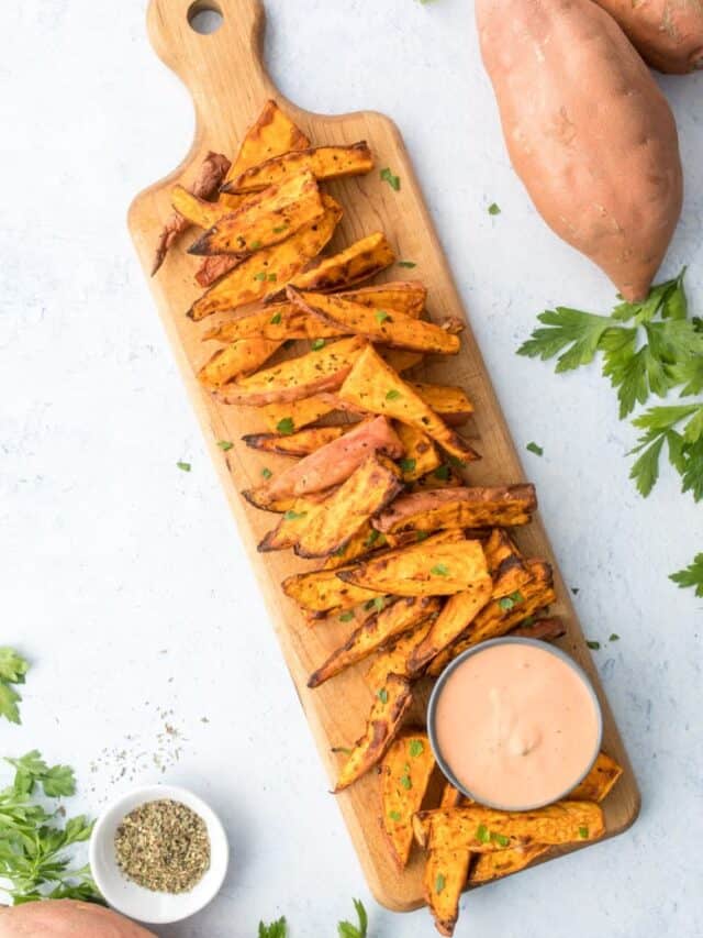 air fried sweet potato wedges on cutting board with dipping sauce