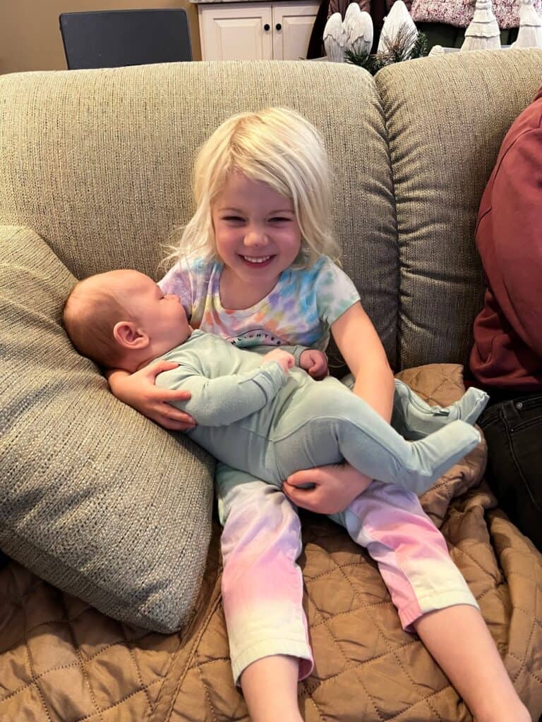 big sister holding baby