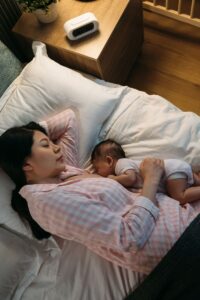 mom breastfeeding baby in bed
