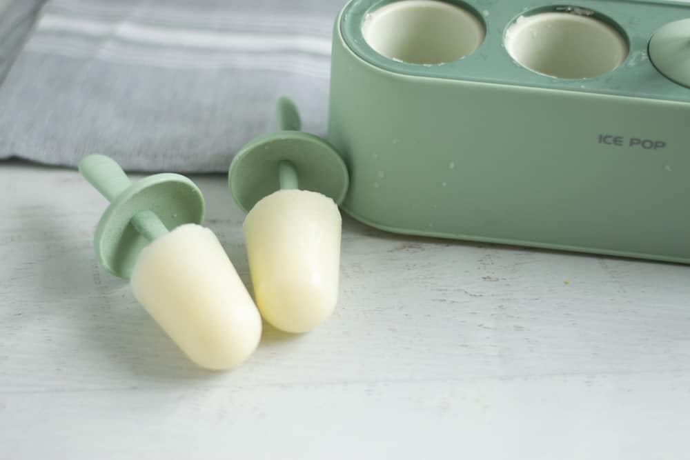 green popsicle mold with breastmilk popsicles