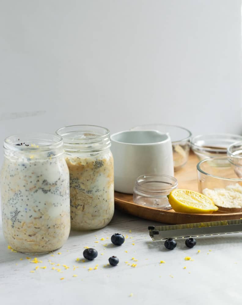 Two mason jars with blueberry lemon overnight oats next to serving platter