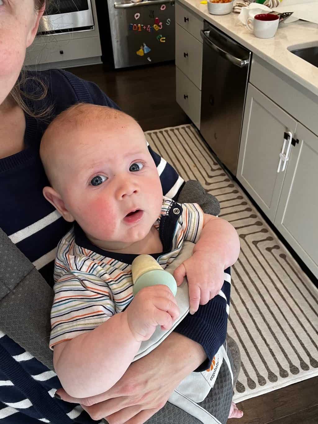 baby holding breastmilk popsicle for teething