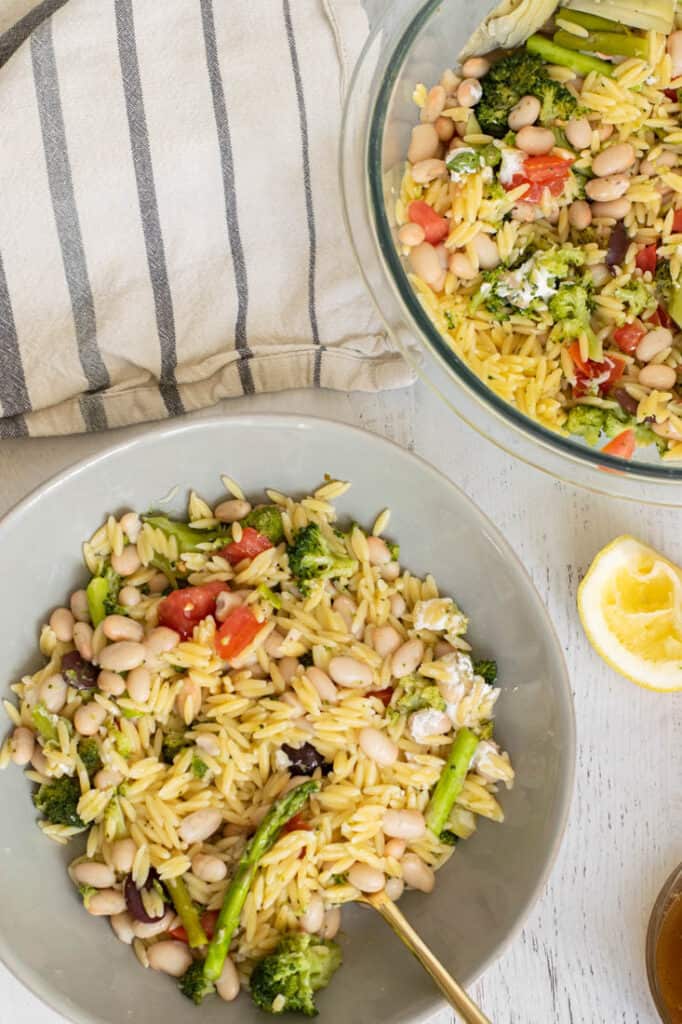 broccoli and asparagus salad with orzo on blue plates for serving