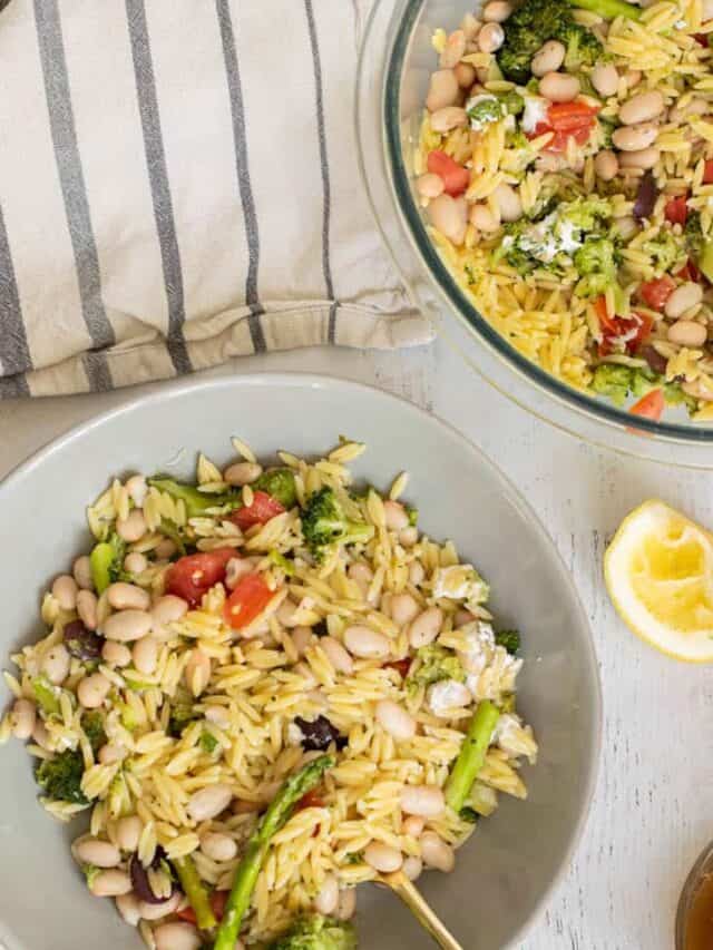 broccoli and asparagus salad with orzo on blue plates for serving