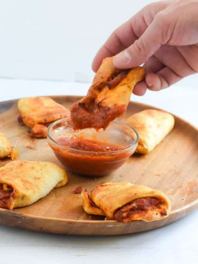 Pizza bites made in the air fryer dipping into pizza sauce