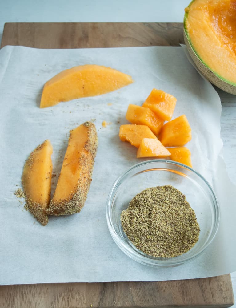 parchment paper with diced cantaloupe and flax seeds