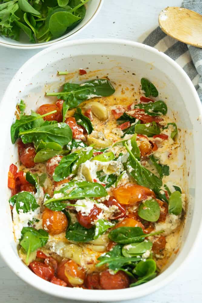 baked goat cheese pasta overhead with spinach and cherry tomatoes