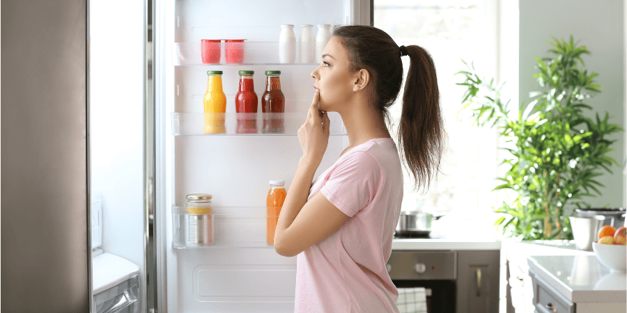 girl looking in the fridge deciding what to eat