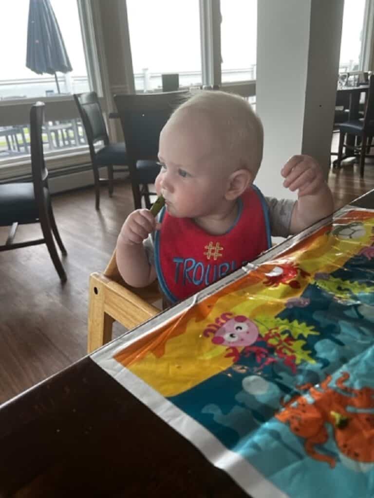 baby eating asparagus at table